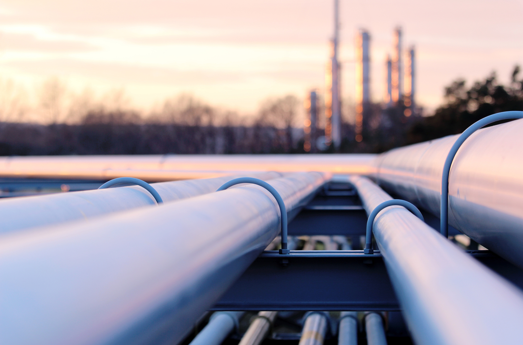 steel long pipes in crude oil factory during sunset