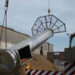 crane lifting steel chimney with platform